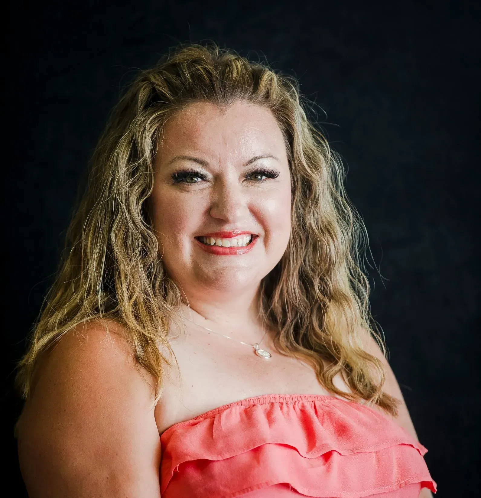 A woman with a braided ponytail is standing in front of a blue sky.