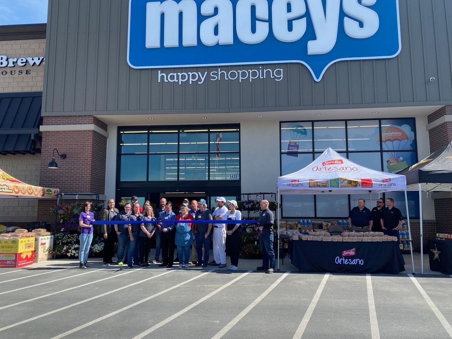 A group of people are standing in front of a macy 's store.