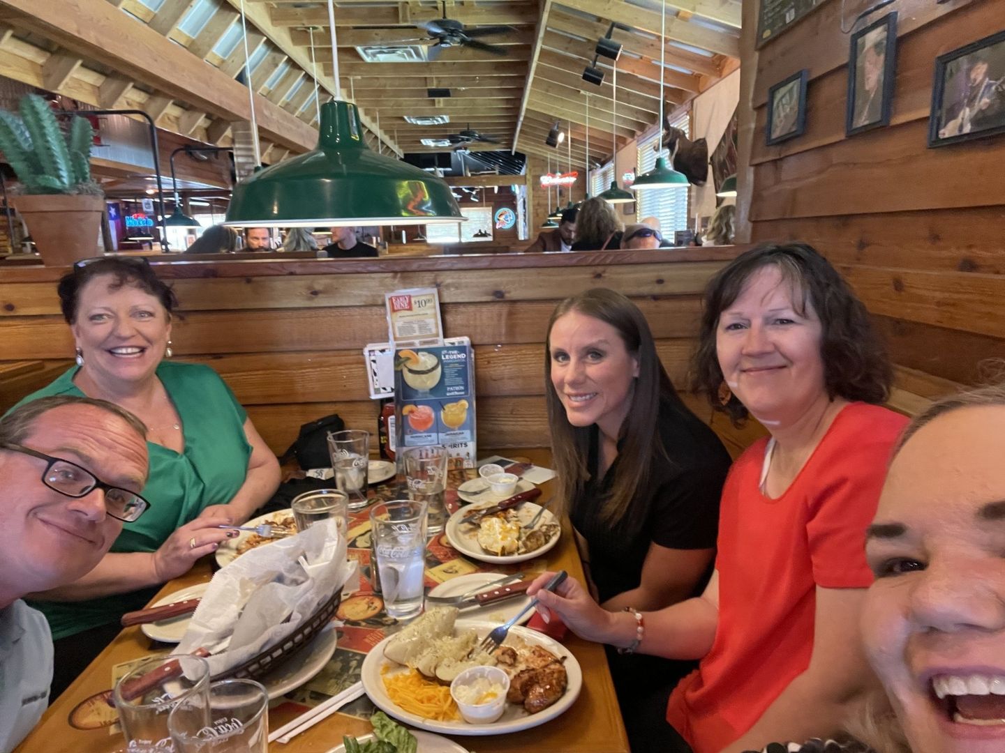 A group of people are sitting at a table in a restaurant eating food.