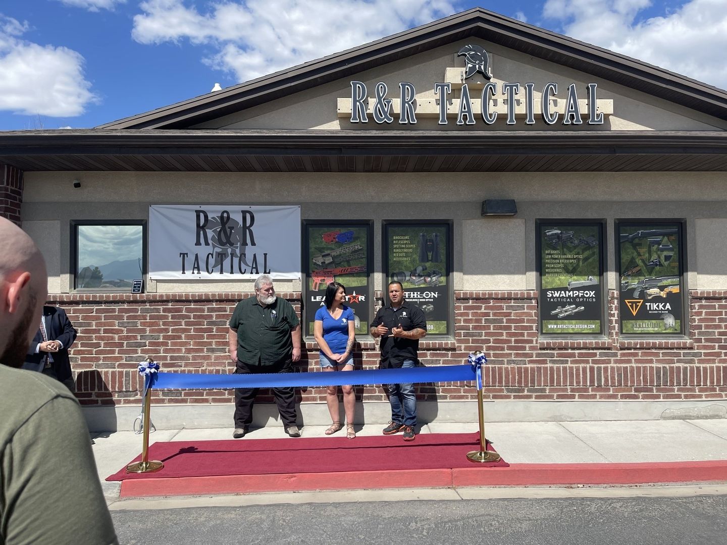 A group of people standing in front of a building that says bar tactical
