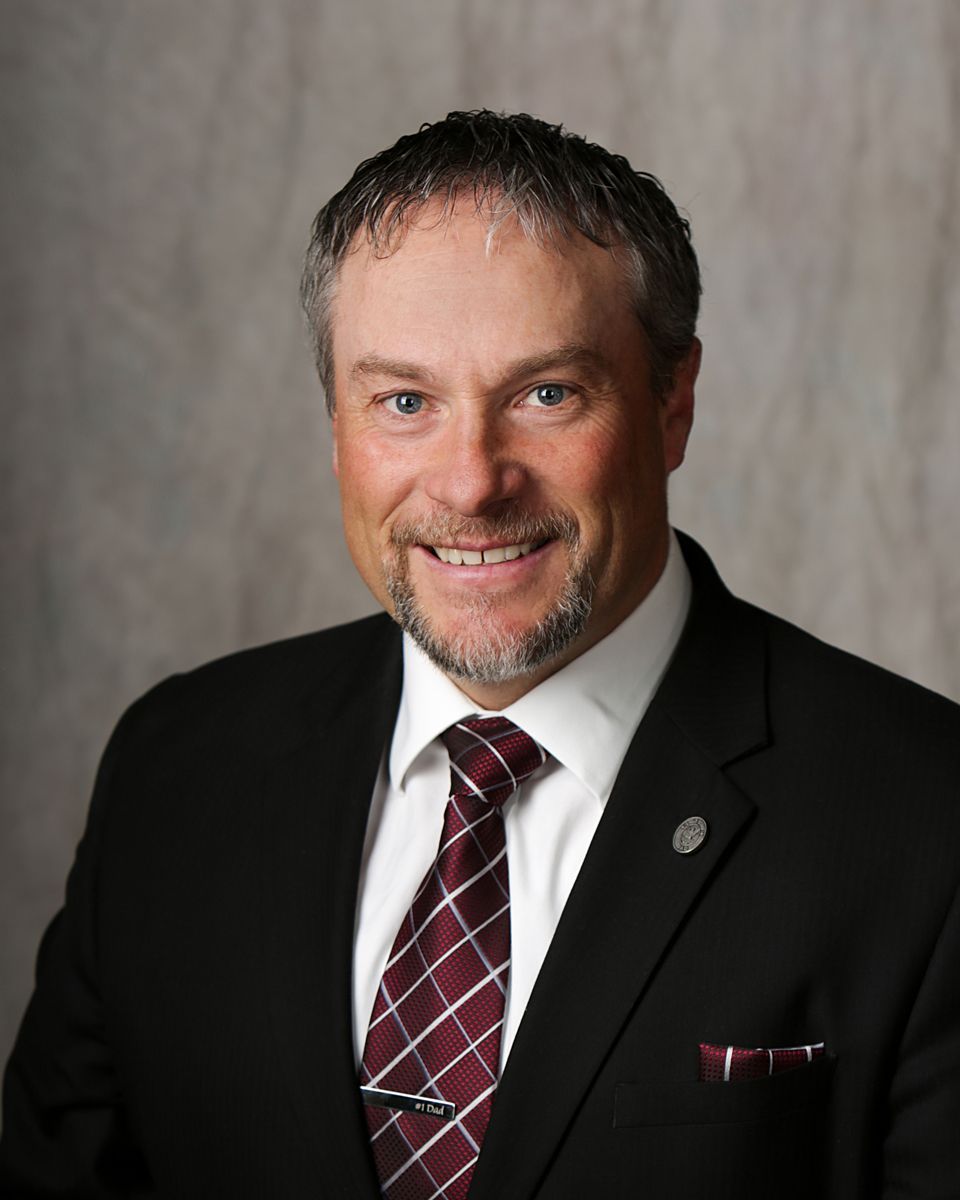 A man in a suit and tie is smiling for the camera