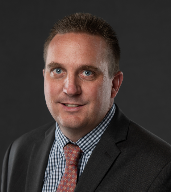 A woman with a braided ponytail is standing in front of a blue sky.