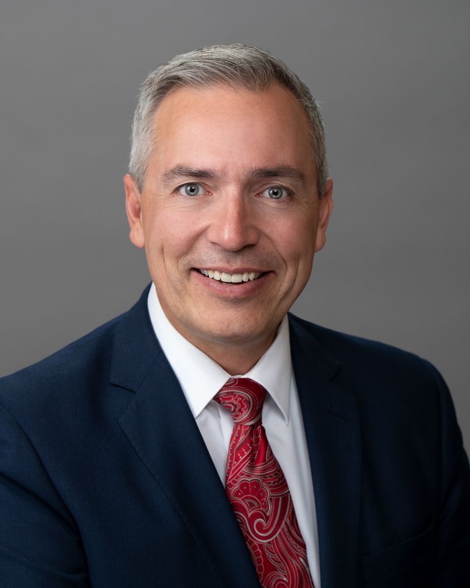 A man in a suit and tie is smiling for the camera.