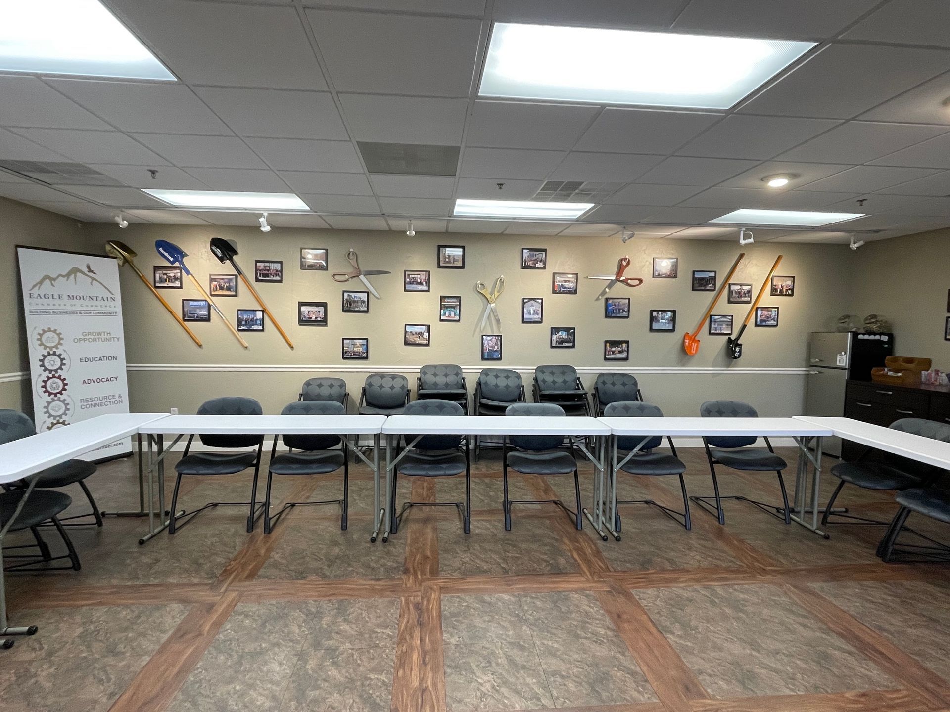 A conference room with tables and chairs and pictures on the wall.