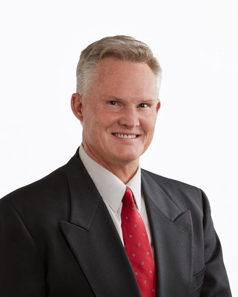 A man in a suit and tie is smiling for the camera