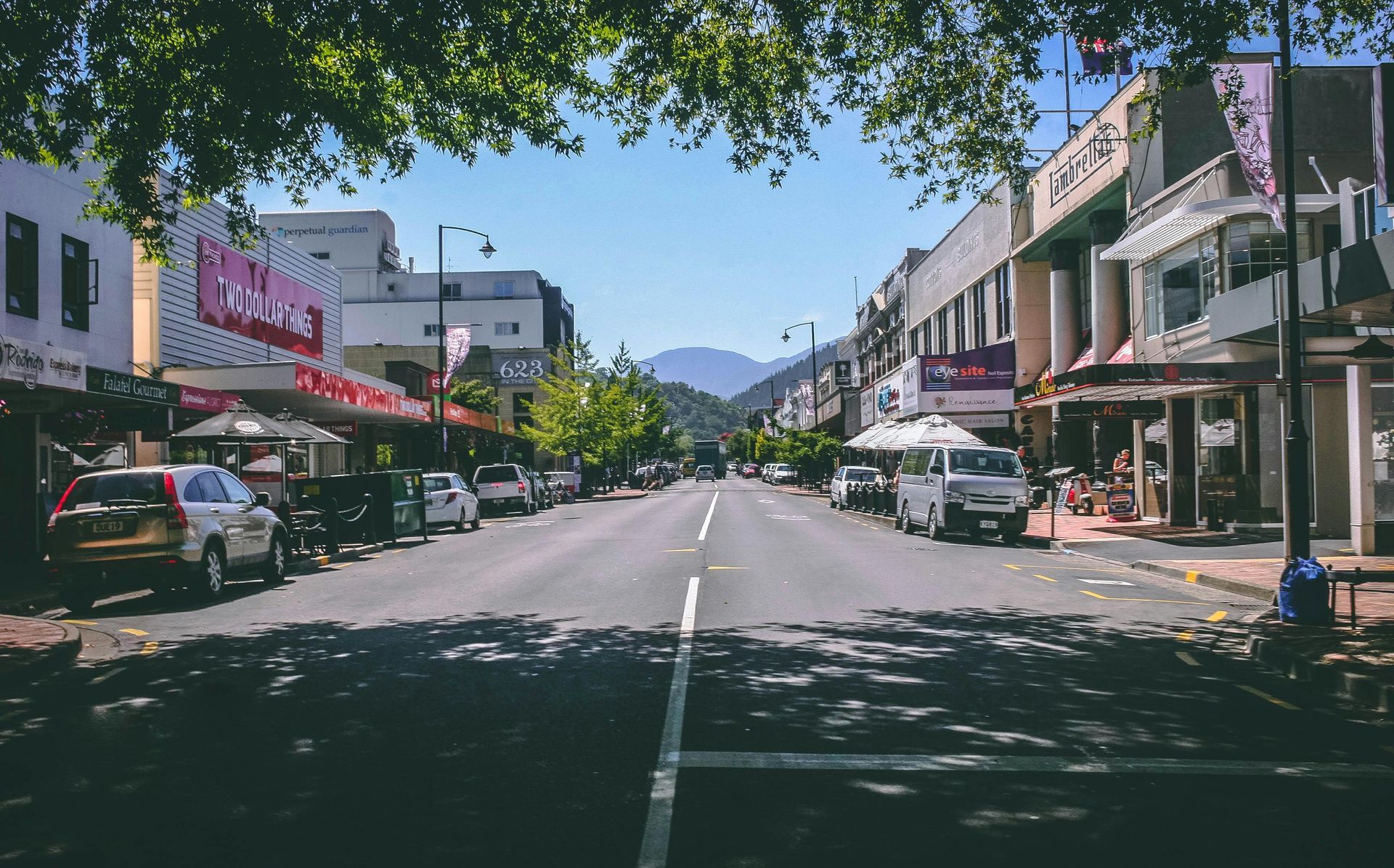 A city street with a lot of cars parked on the side of it.