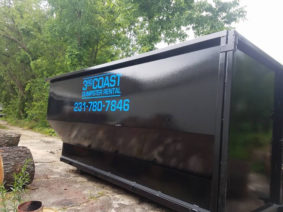 Black dumpster with blue text: "3rd Coast Dumpster Rental" and phone number.