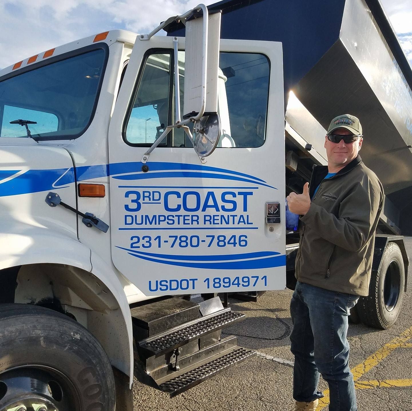 Man next to a 3rd Coast Dumpster Rental truck, giving a thumbs-up.