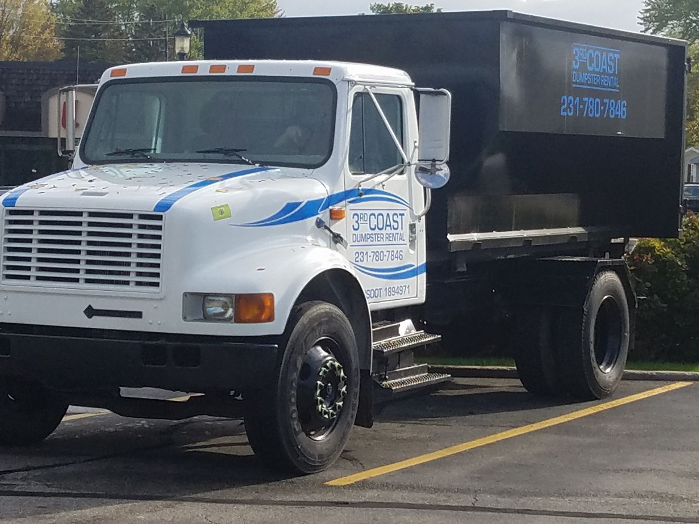 White and black 3 Coast Construction dump truck parked in a lot.