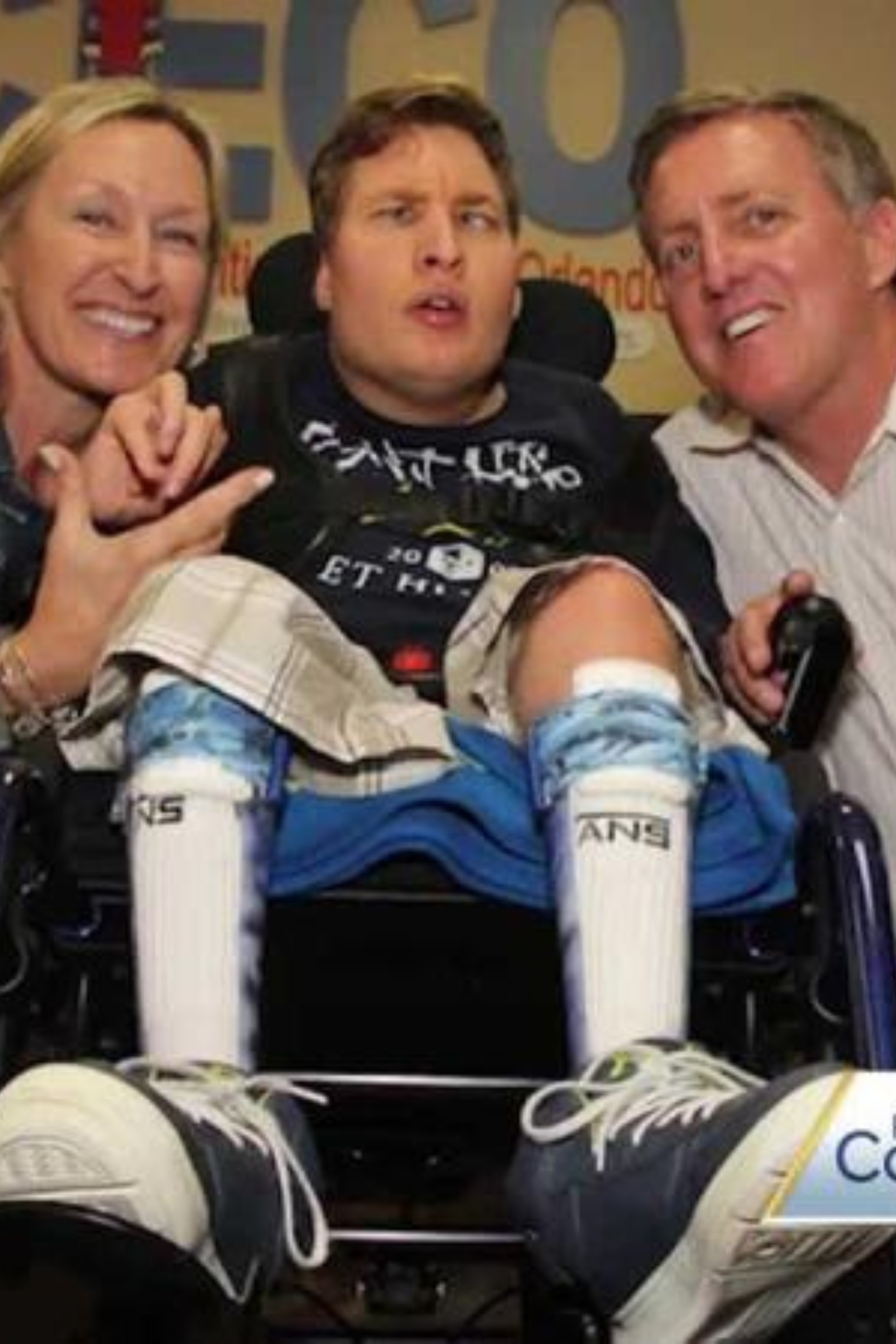 A man in a wheelchair is surrounded by his family