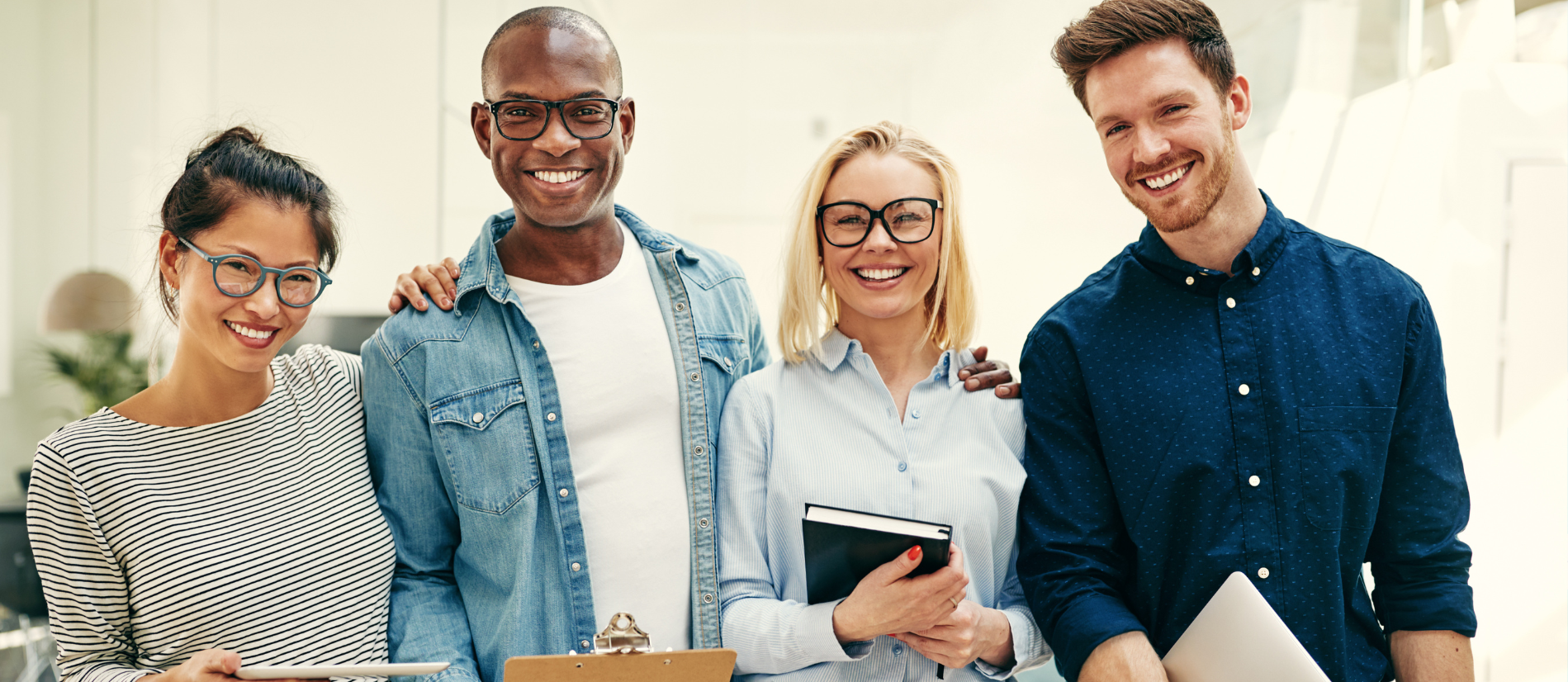 Smiling group of young businesspeople standing in an office