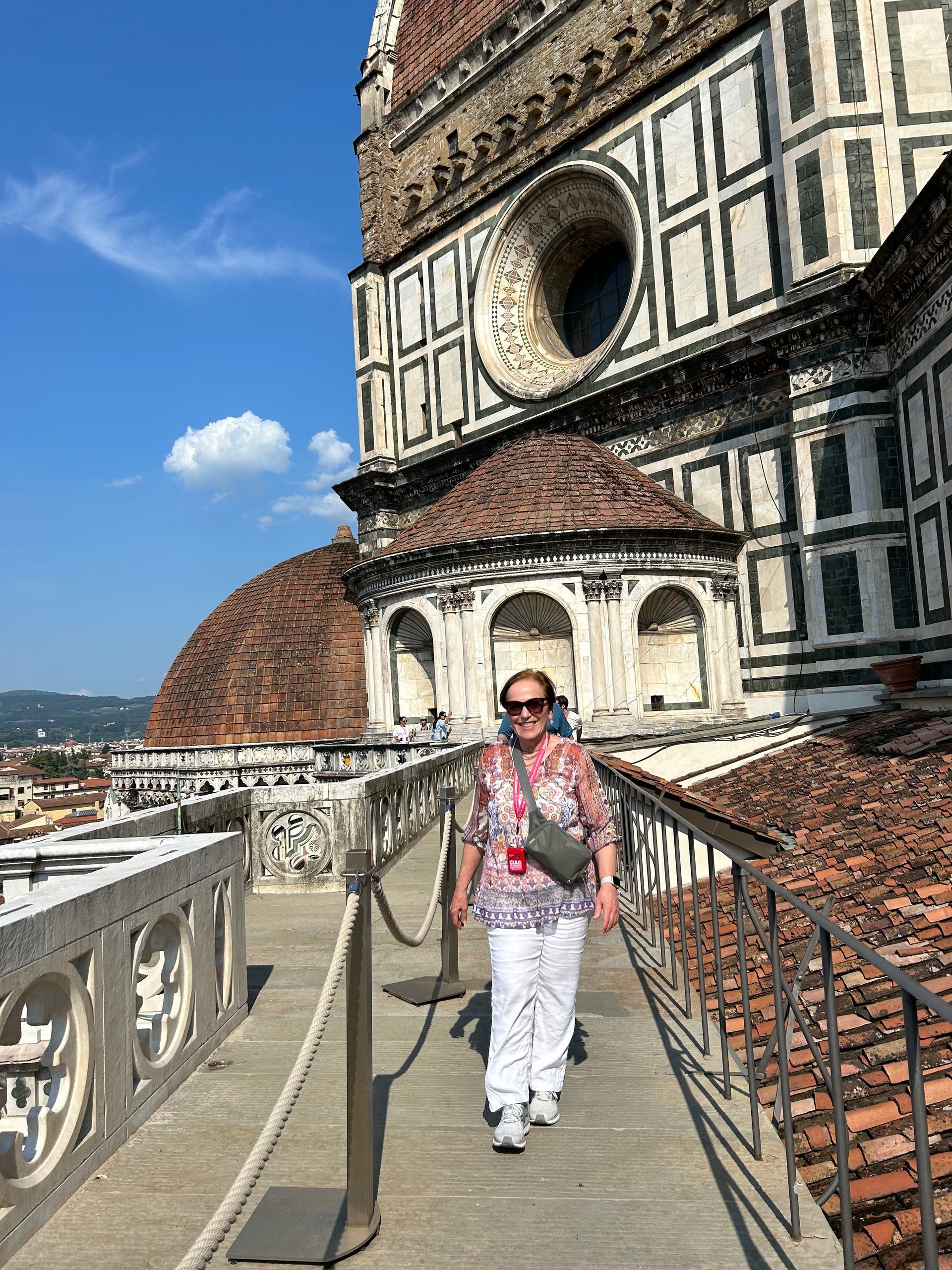 A woman is walking down a sidewalk in front of a large building
