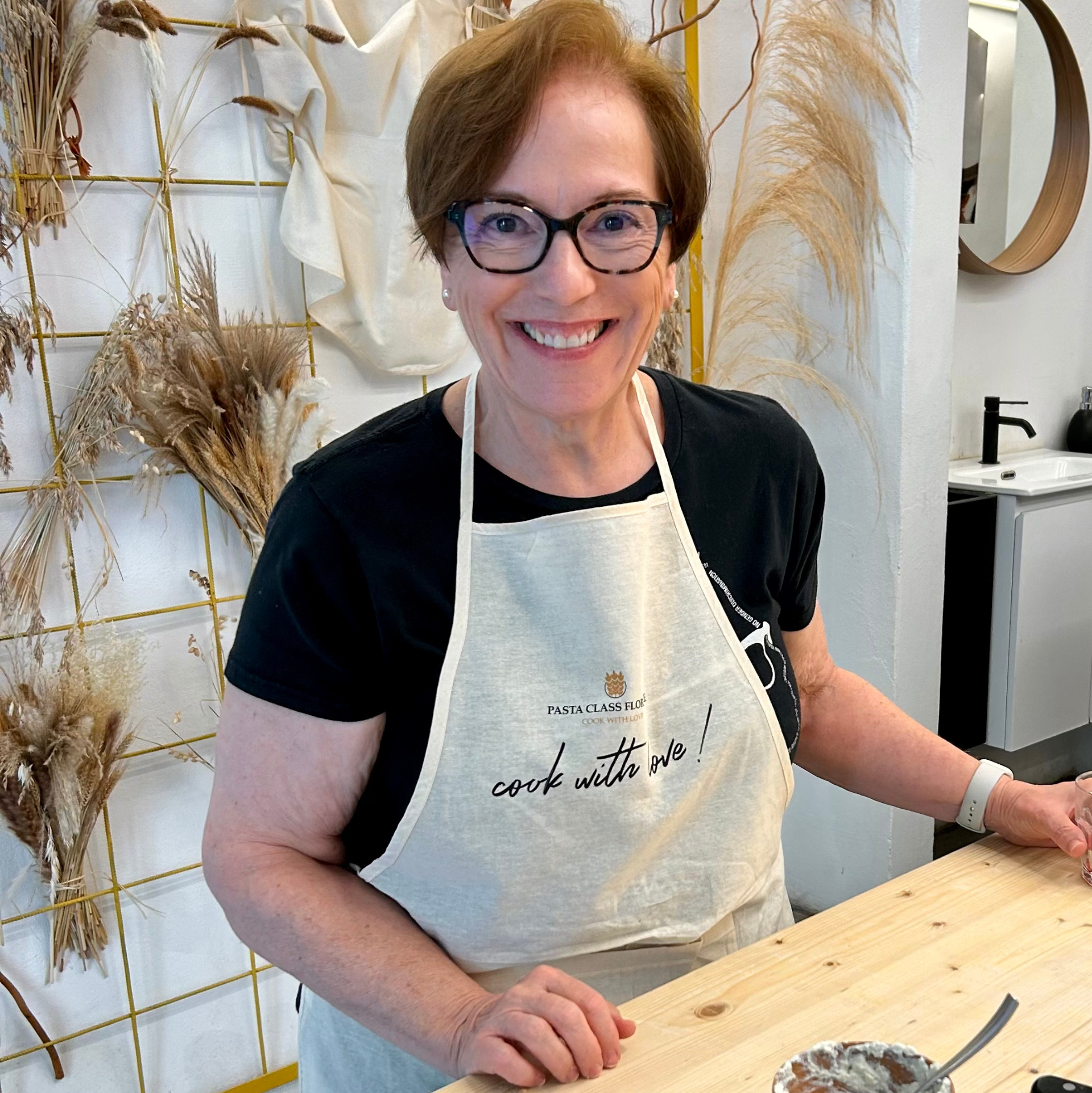 A woman wearing an apron that says cook like me
