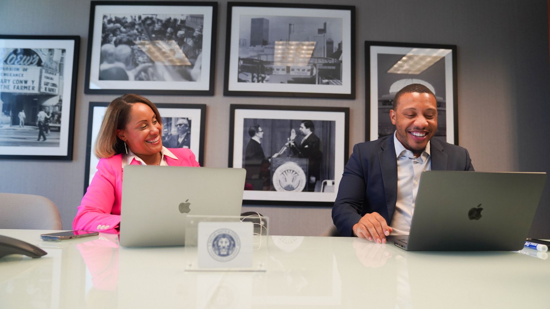 A group of women are sitting at a table with laptops.