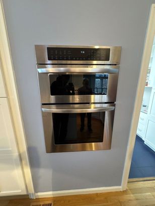 A stainless steel double oven is built into a wall in a kitchen.