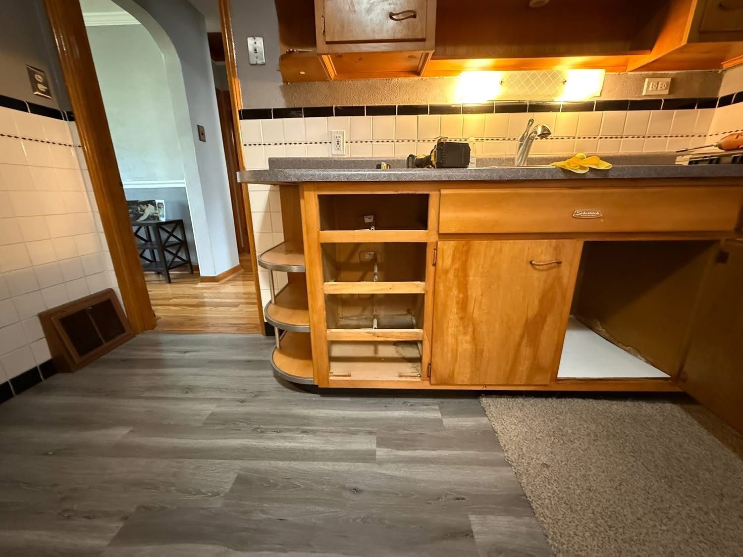A stainless steel dishwasher is sitting under a sink in a kitchen.