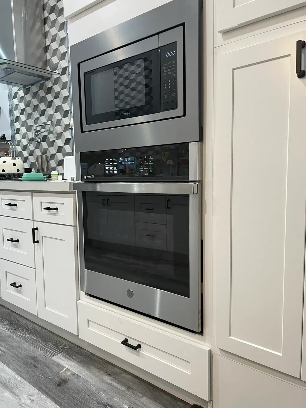 A kitchen with a stainless steel oven and microwave.