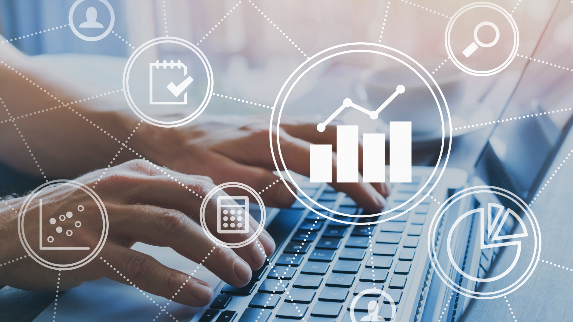 A person is typing on a laptop computer with a graph on the screen