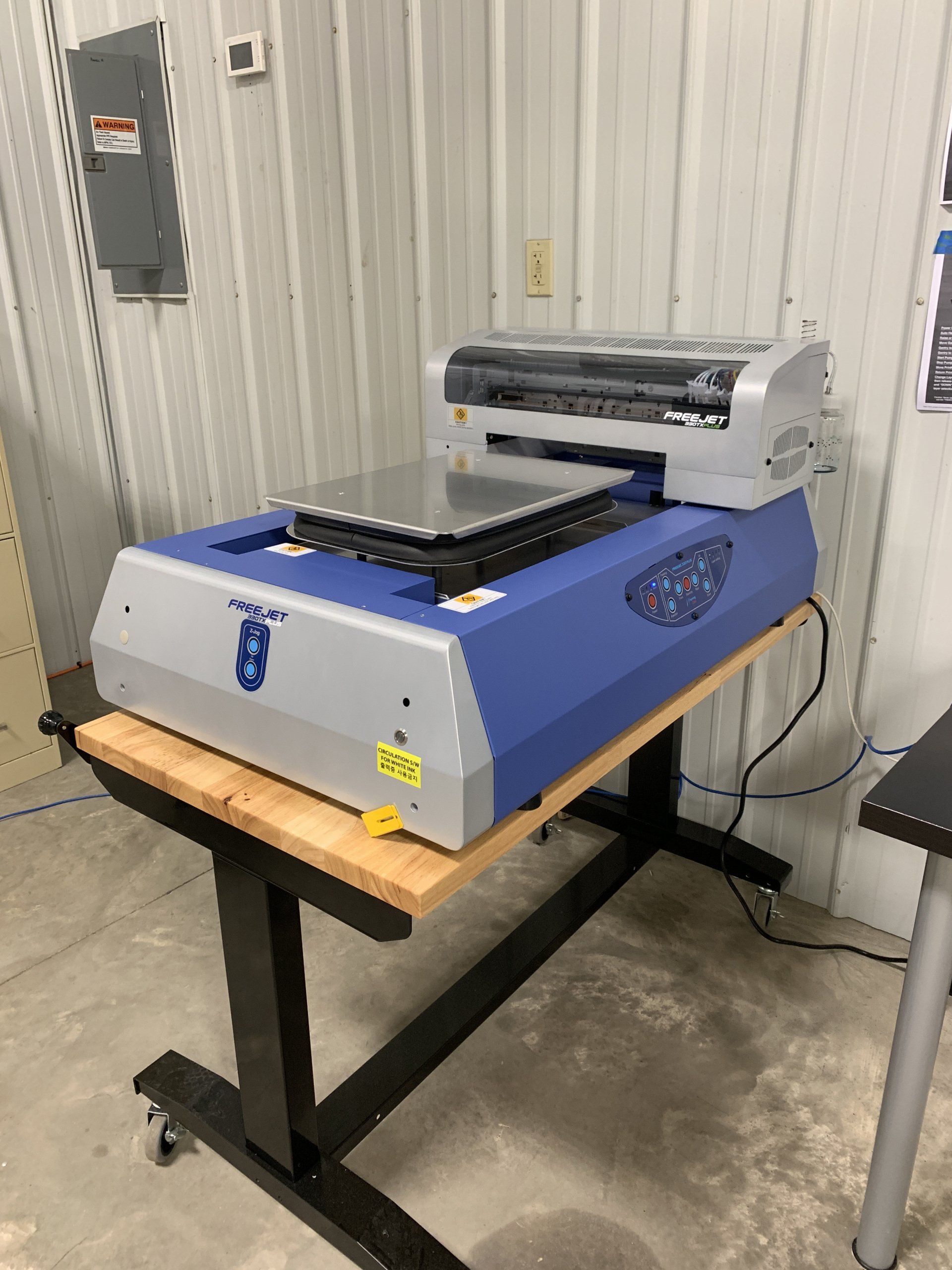 A printer is sitting on top of a wooden table.