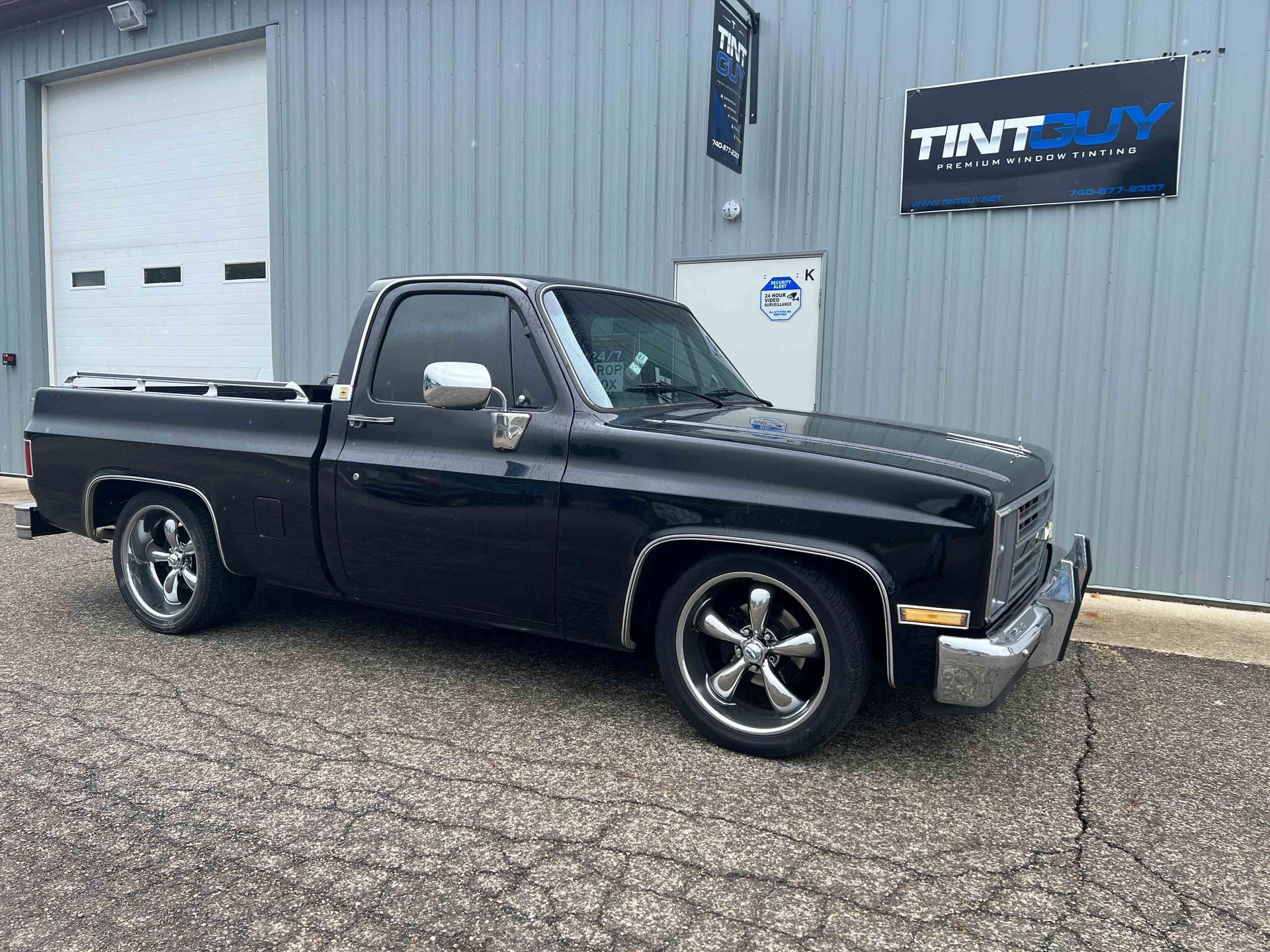 A black truck is parked in front of a building.