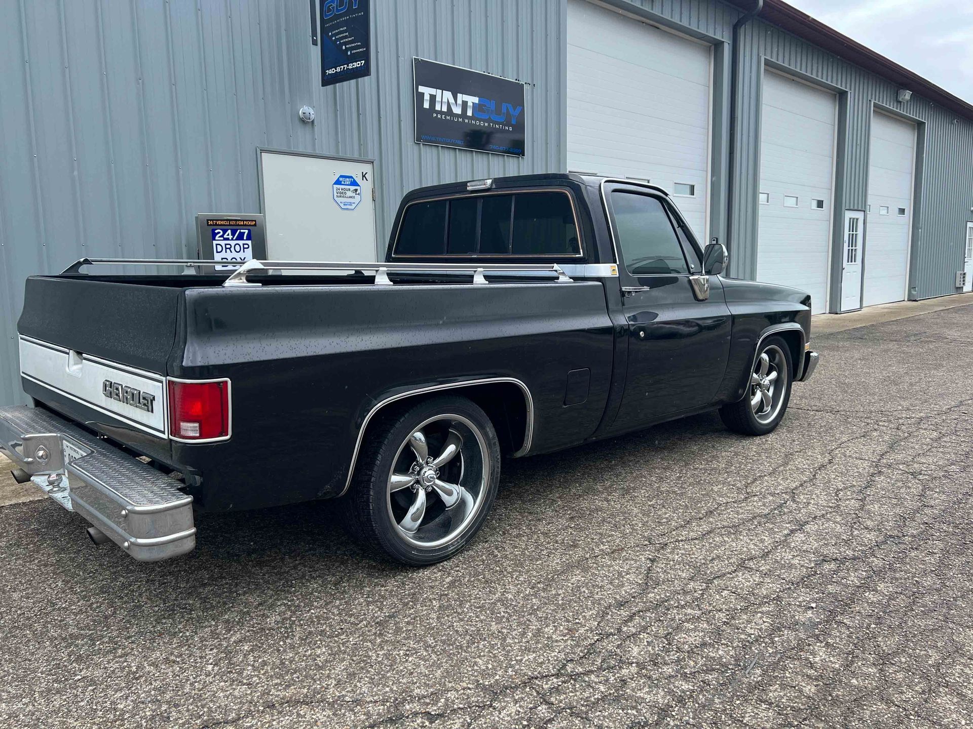 A black truck is parked in front of a building.