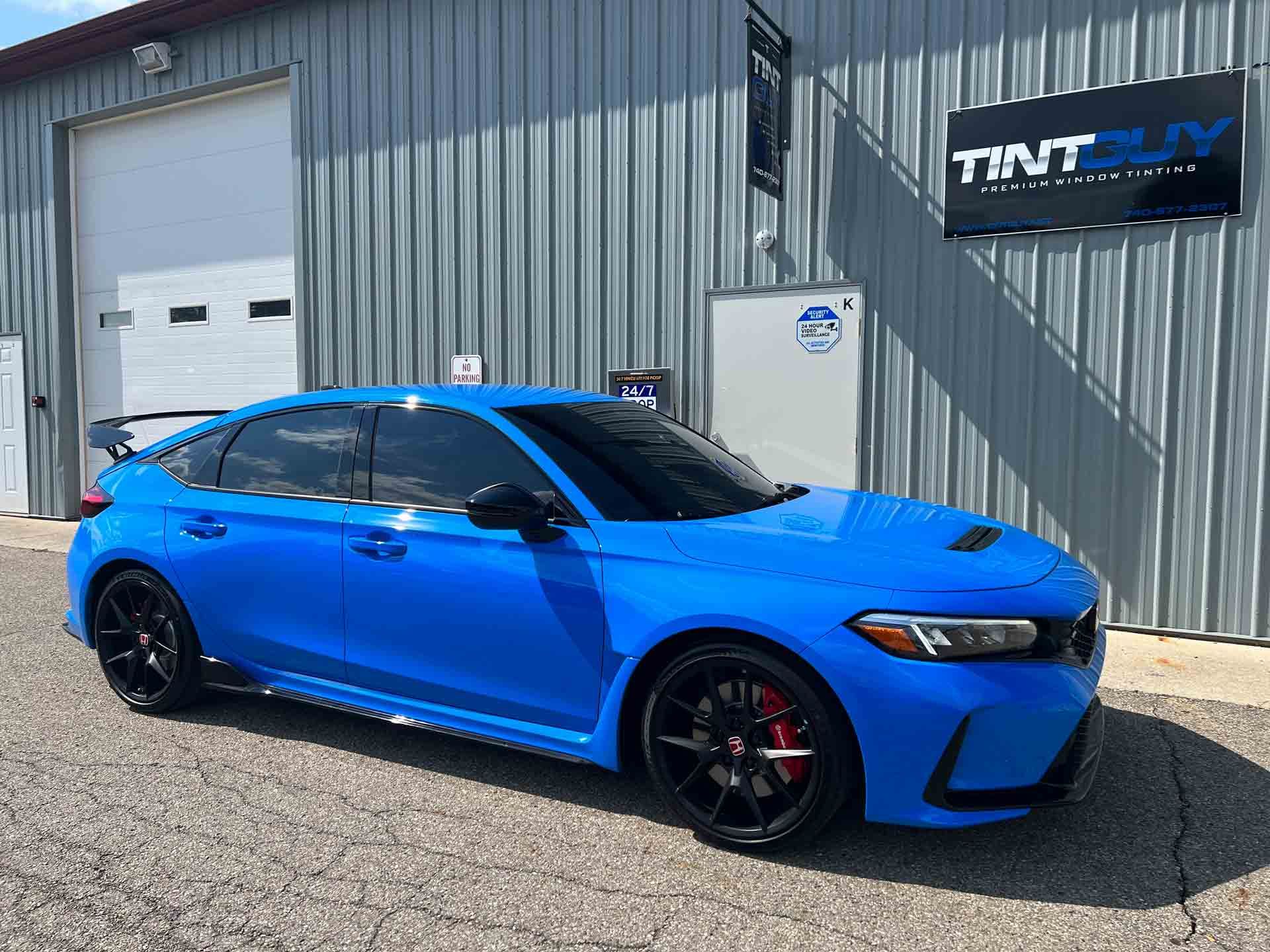 A blue car is parked in front of a building.