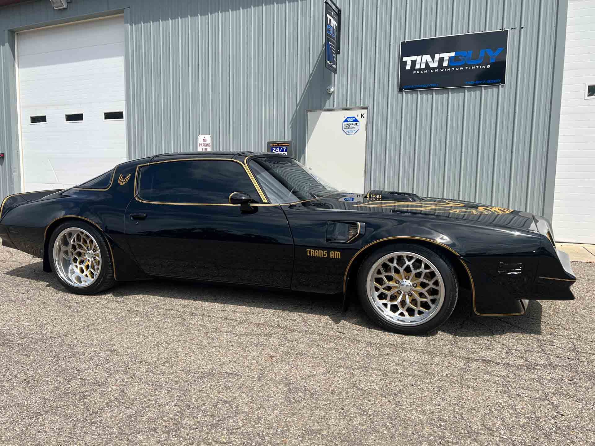 A black car is parked in front of a building.