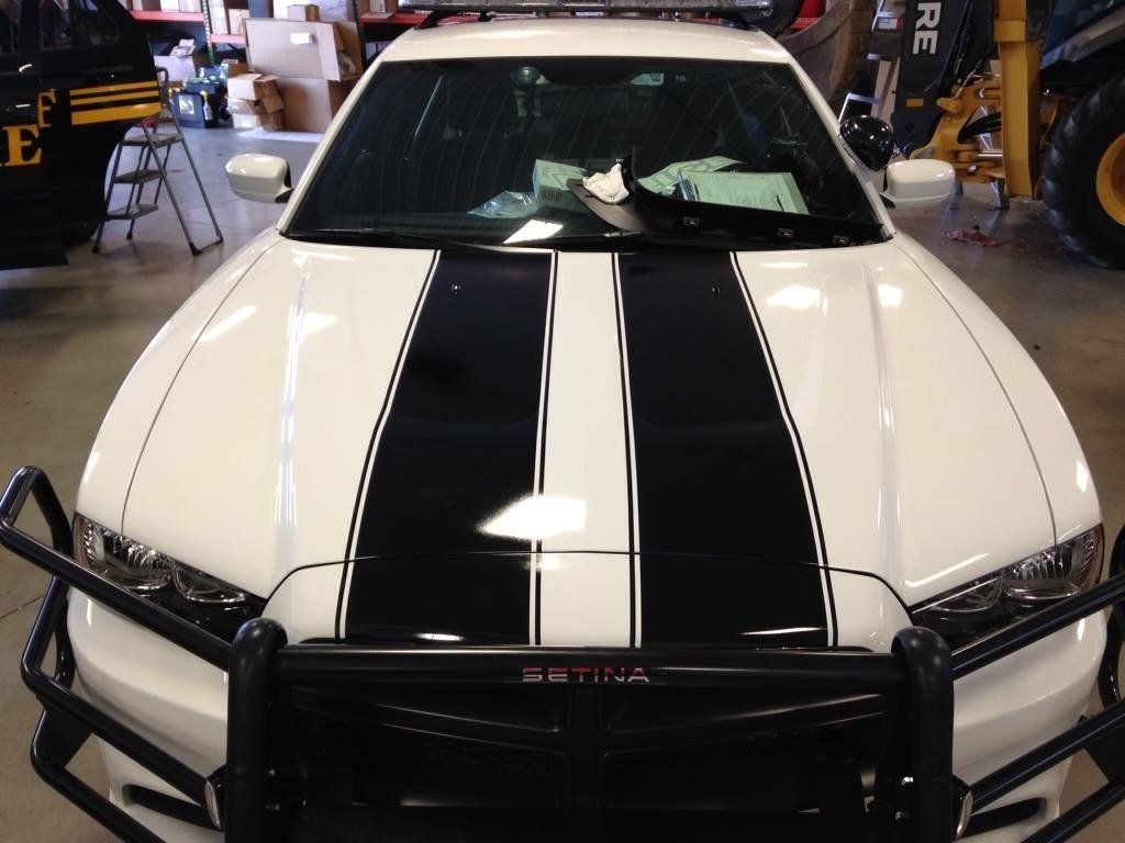 A white satina car with black stripes on the hood
