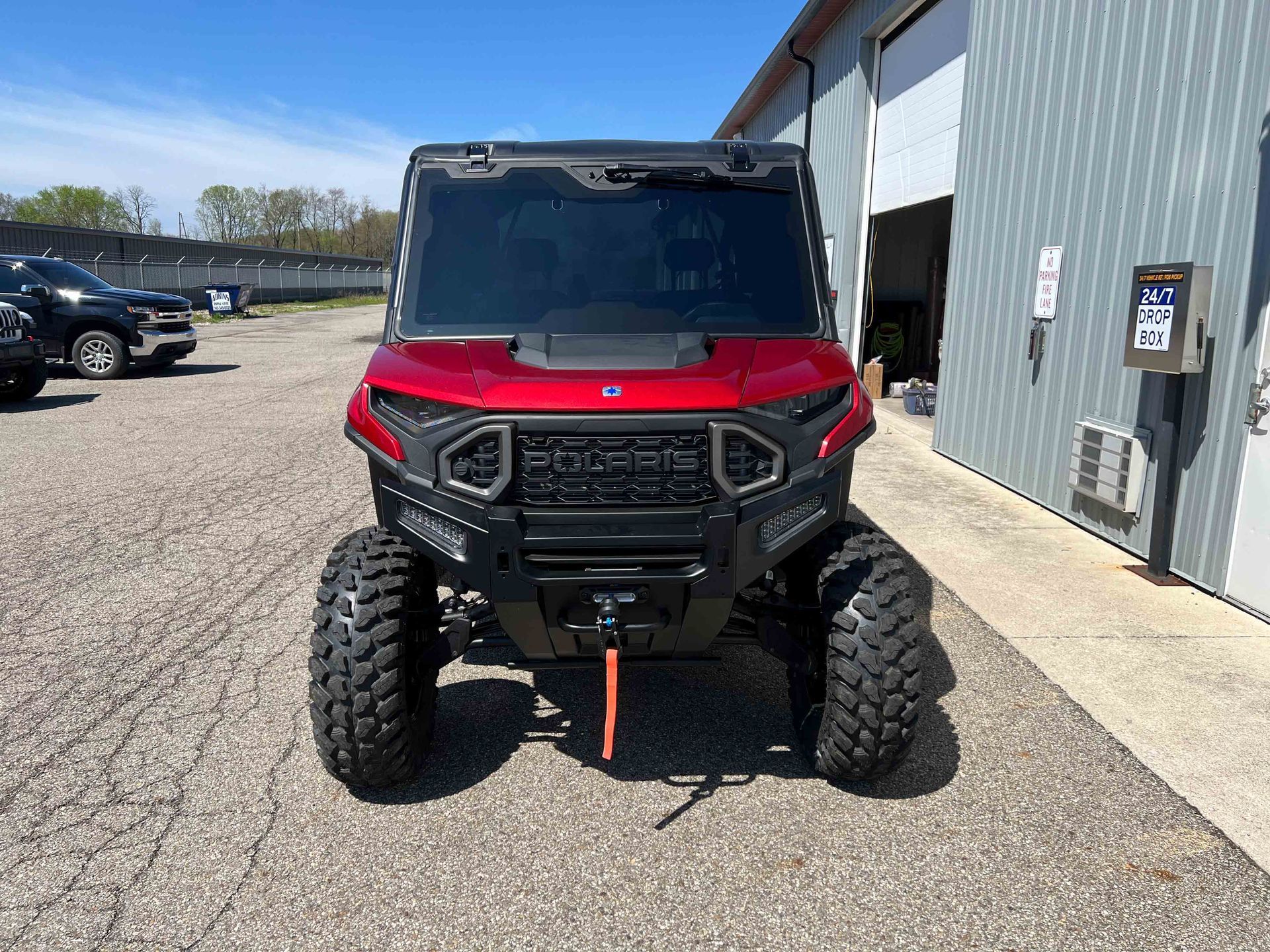 A red atv is parked in front of a building.