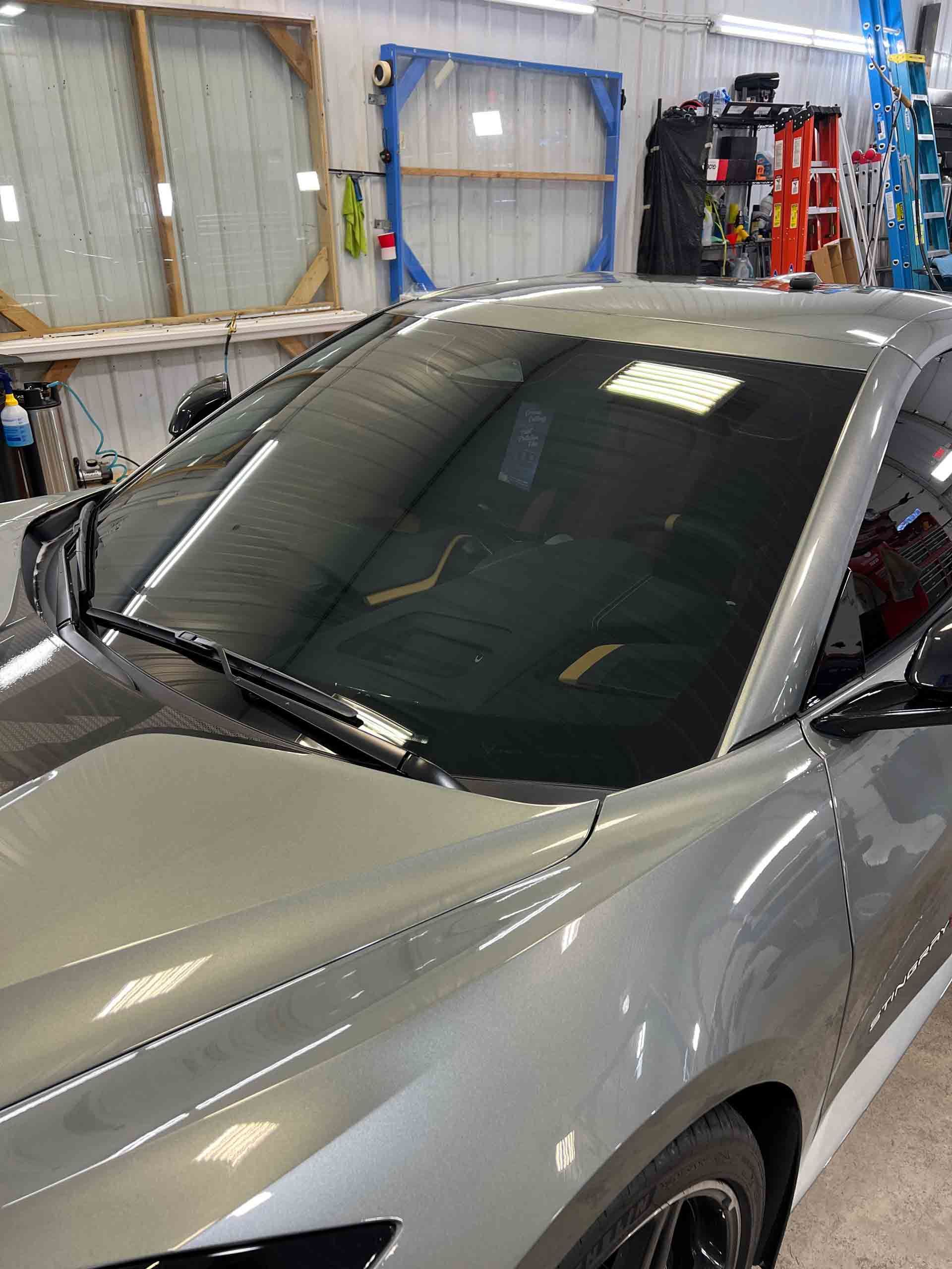 A silver sports car is parked in a garage.
