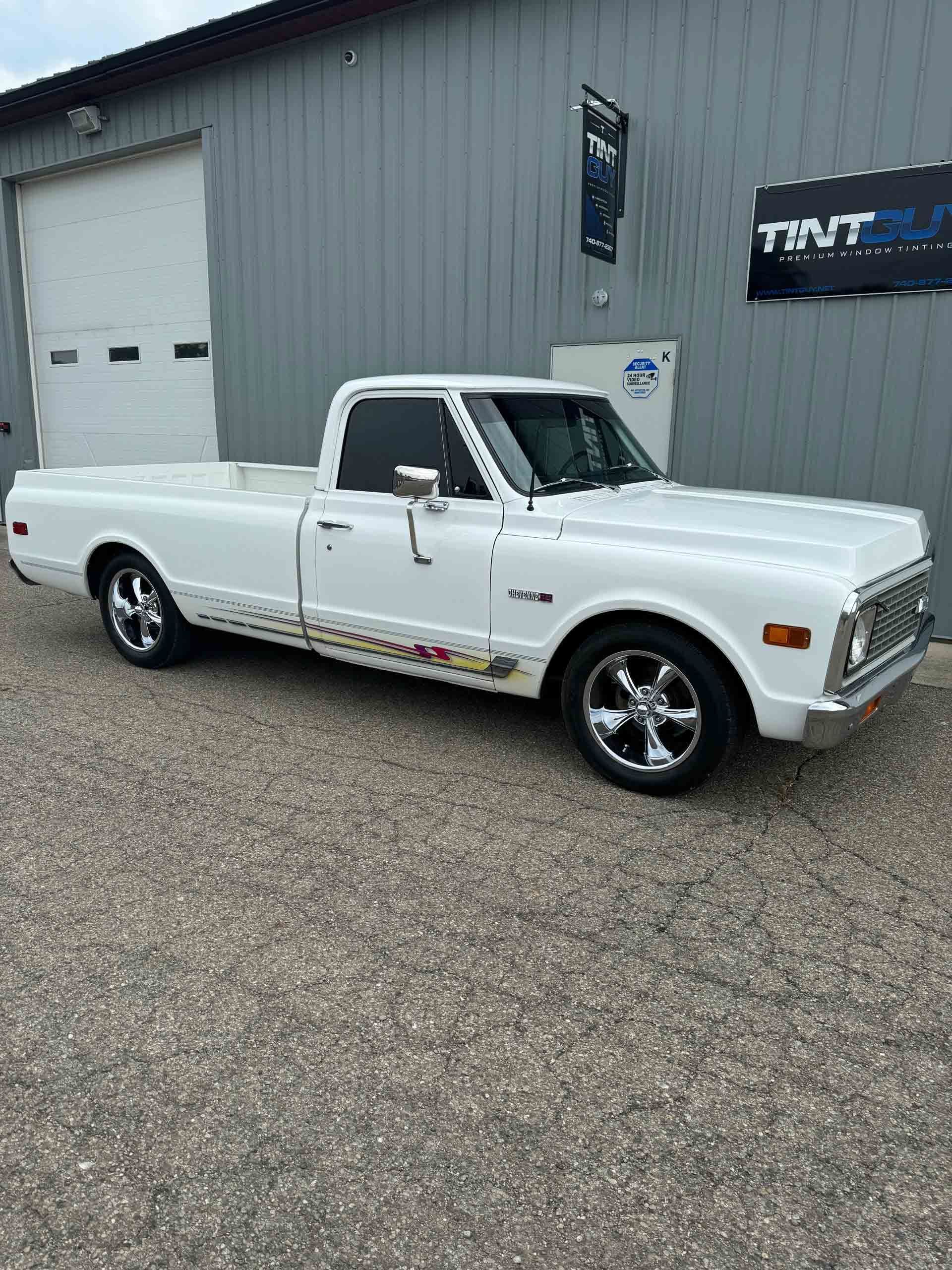 A white truck is parked in front of a building.