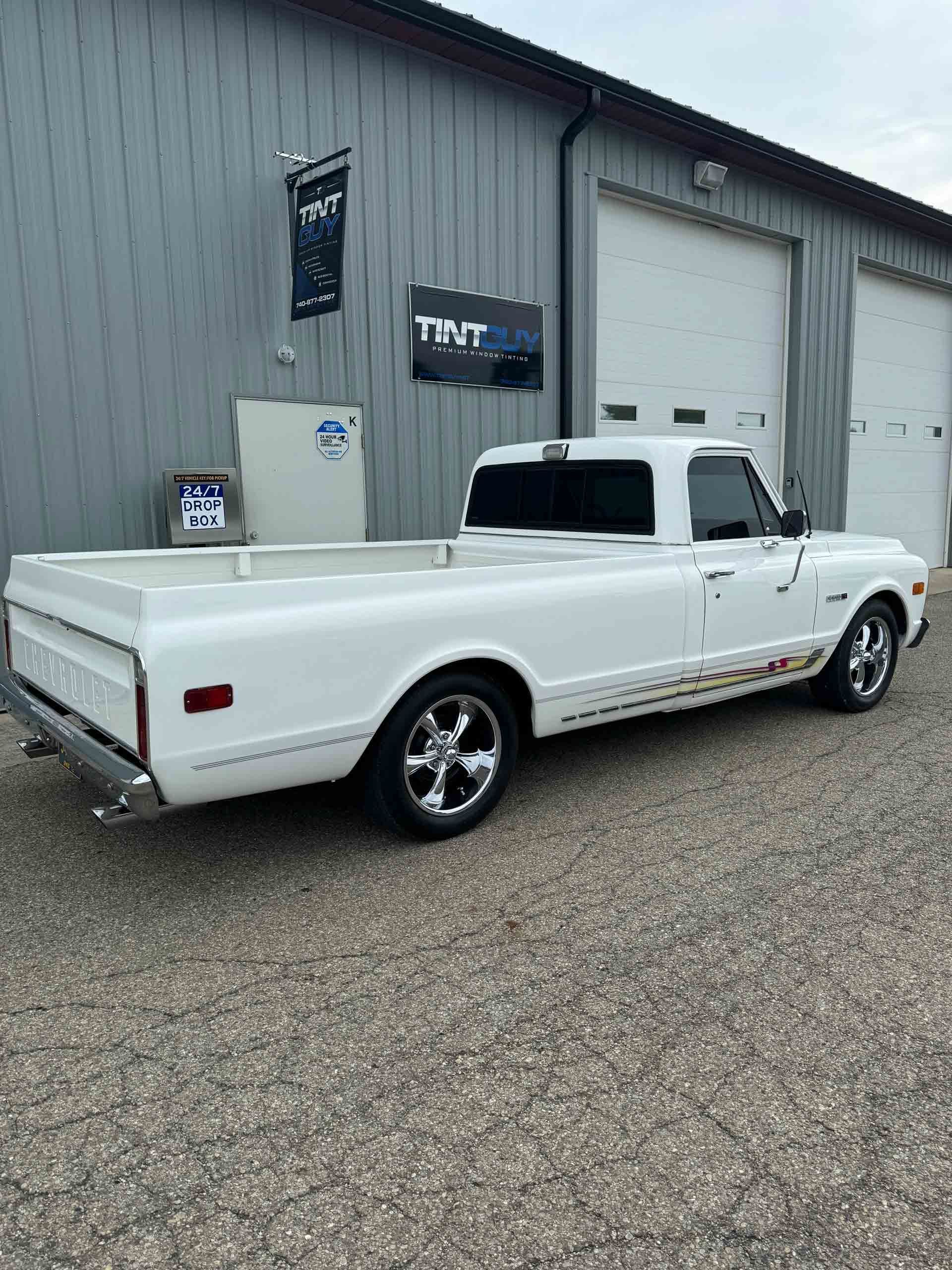 A white truck is parked in front of a building.