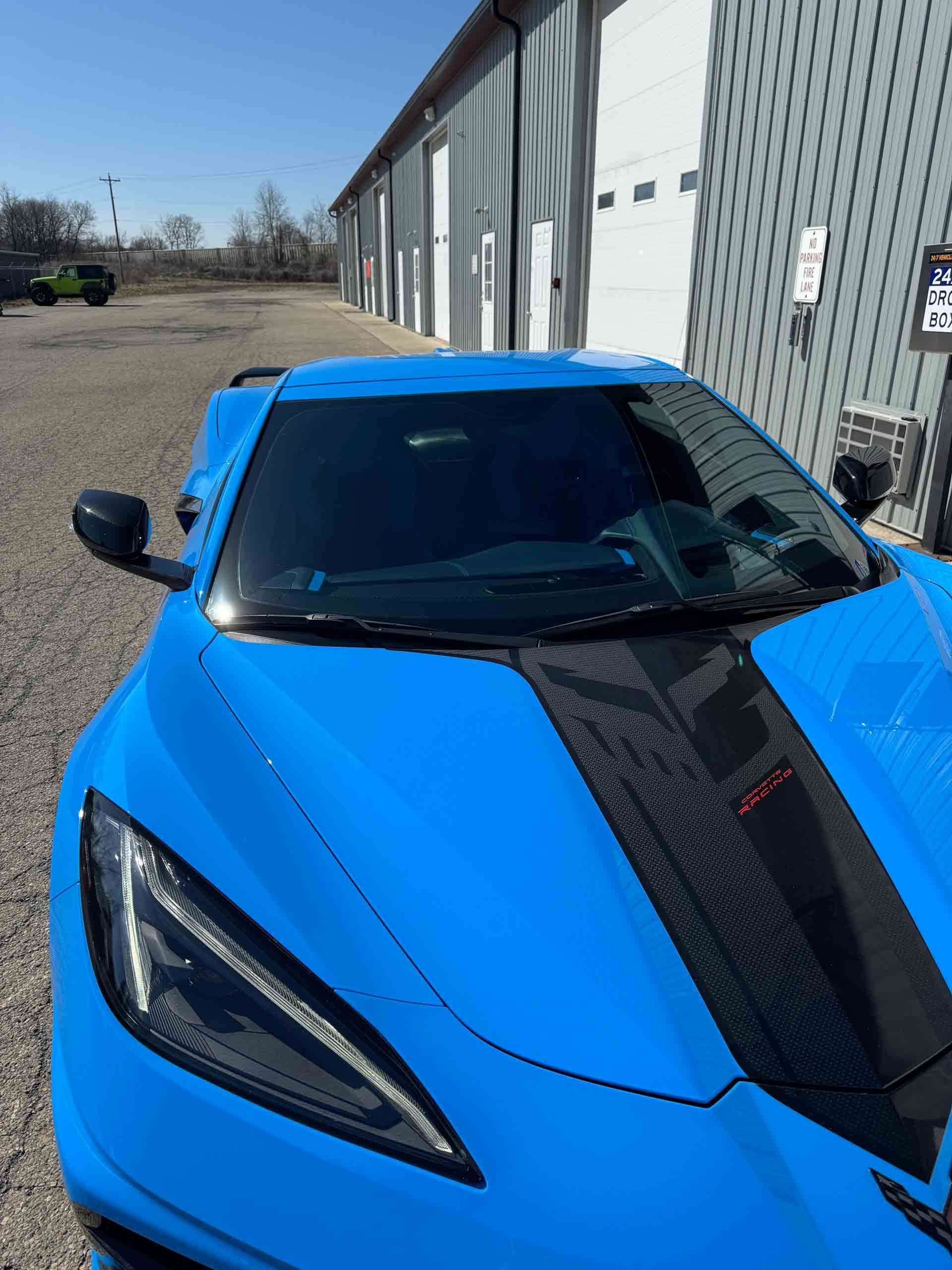 A blue sports car is parked in front of a building