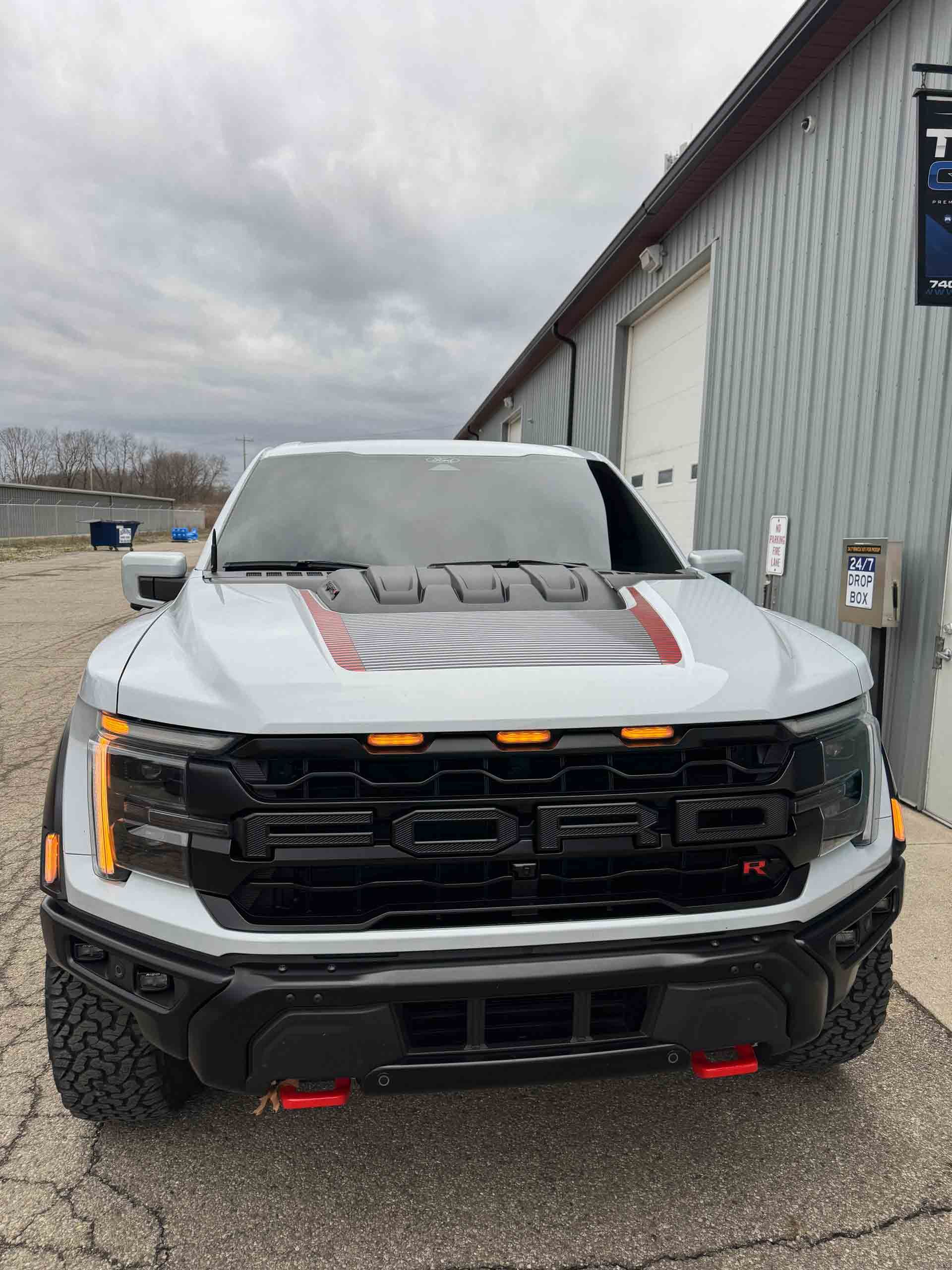 A white truck is parked in front of a building.