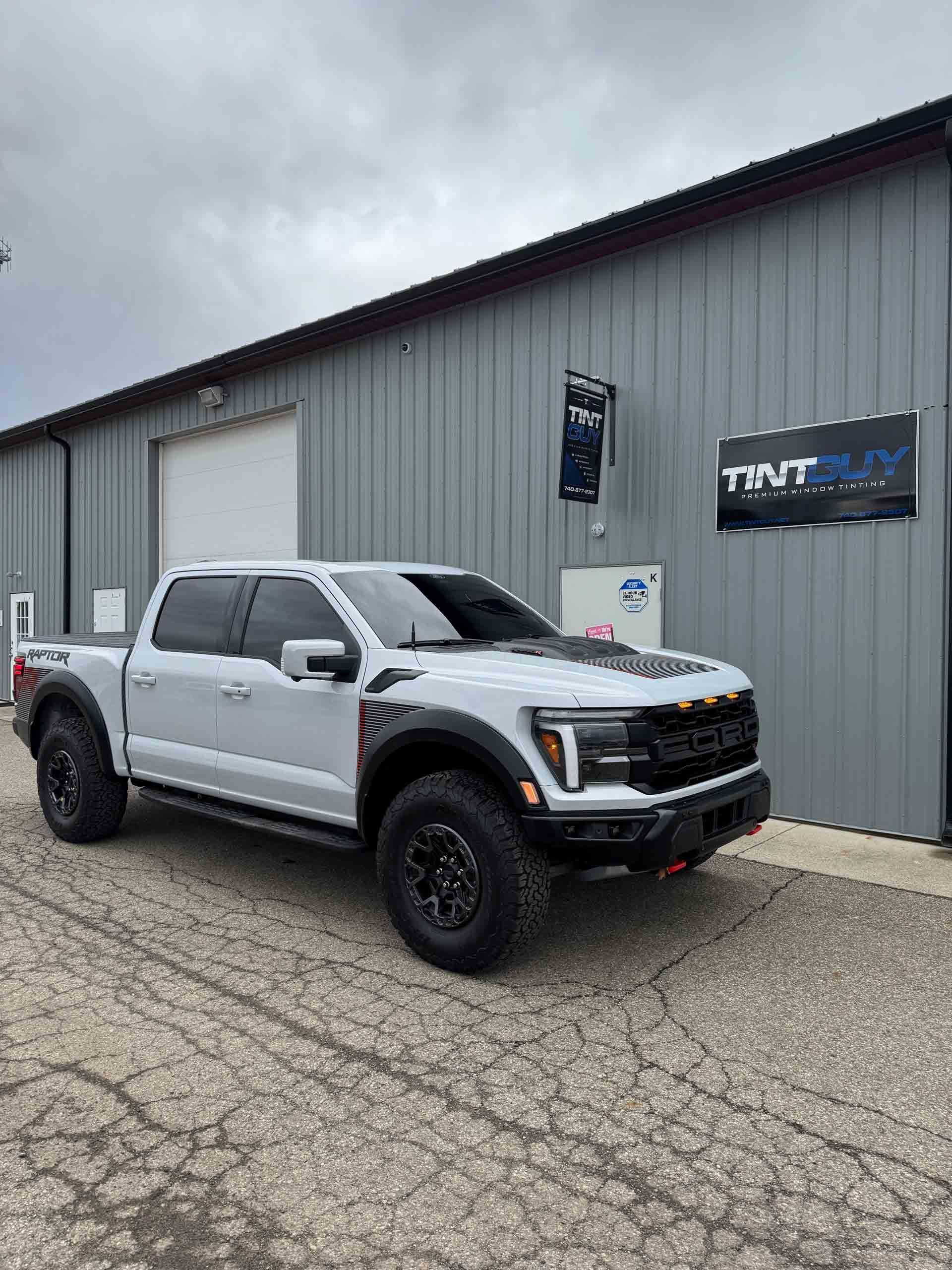 A white truck is parked in front of a building.