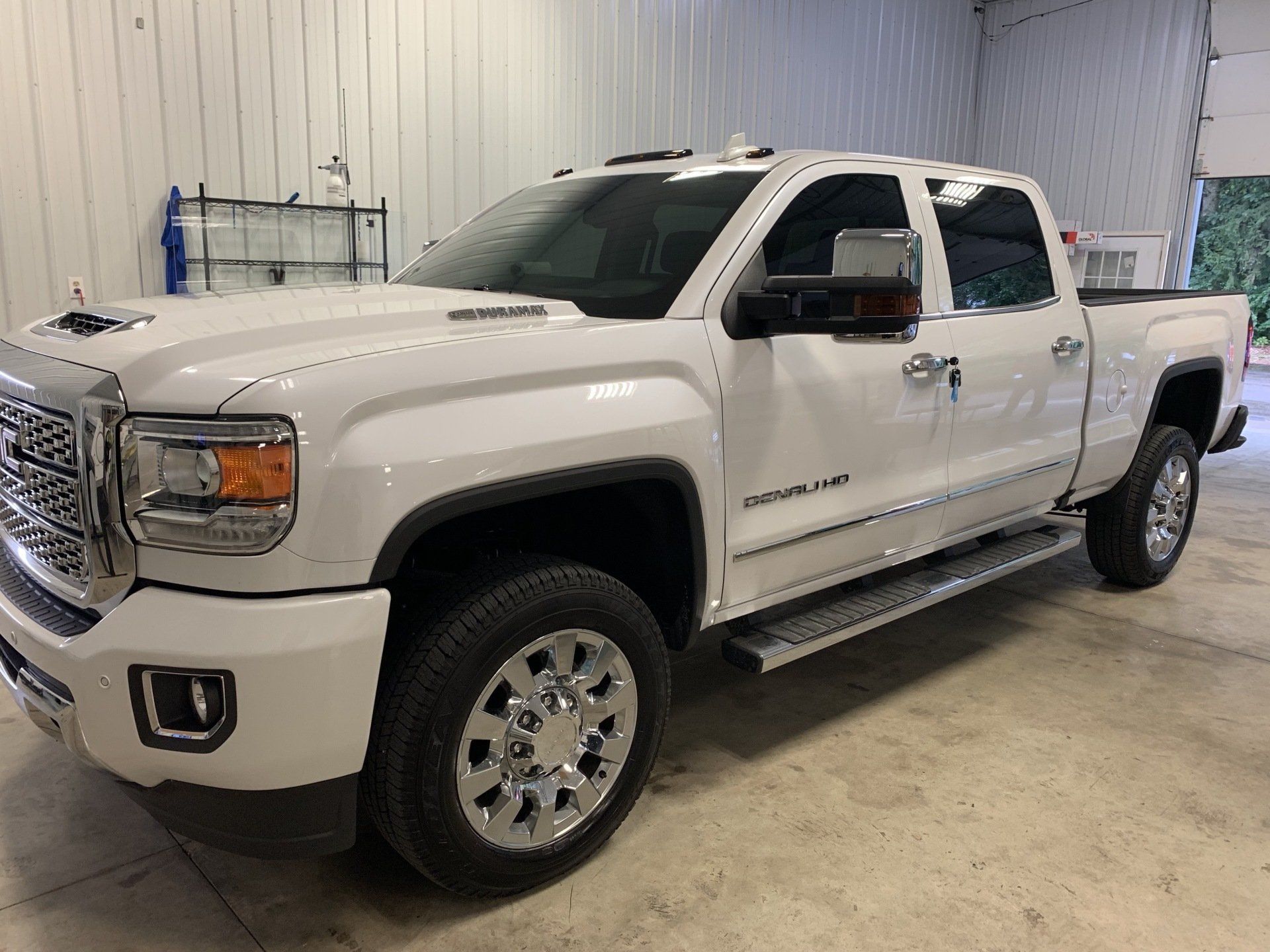 A white pickup truck is parked in a garage.