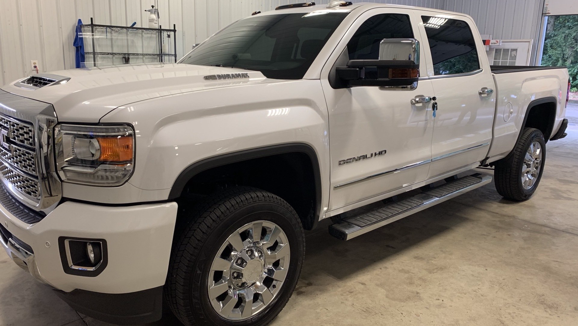 A white pickup truck is parked in a garage.