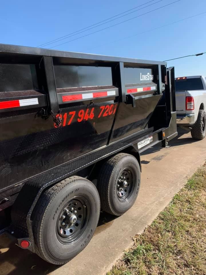 A dump truck is parked on the side of the road next to a truck.
