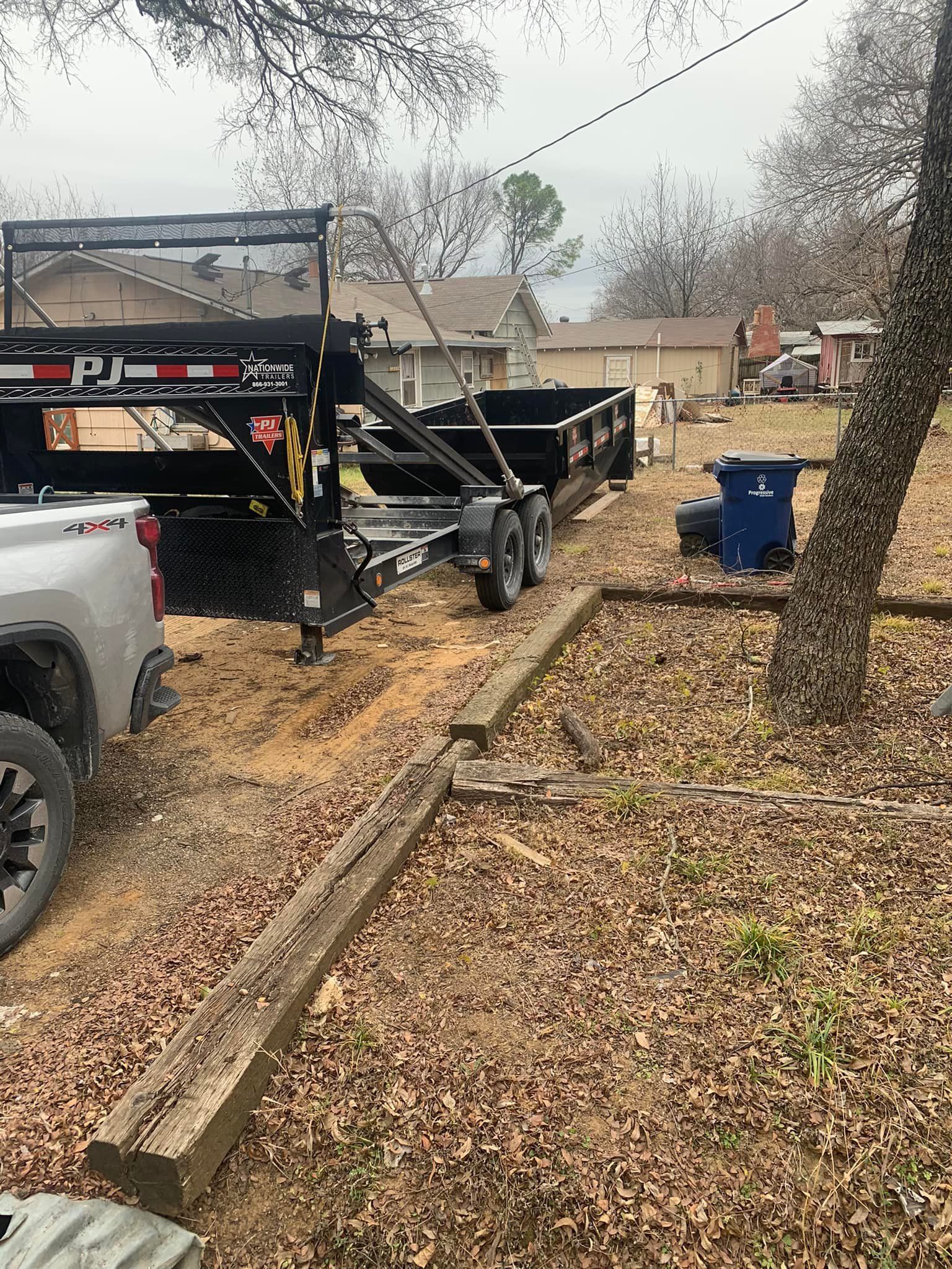 A trailer is parked in a yard next to a truck.