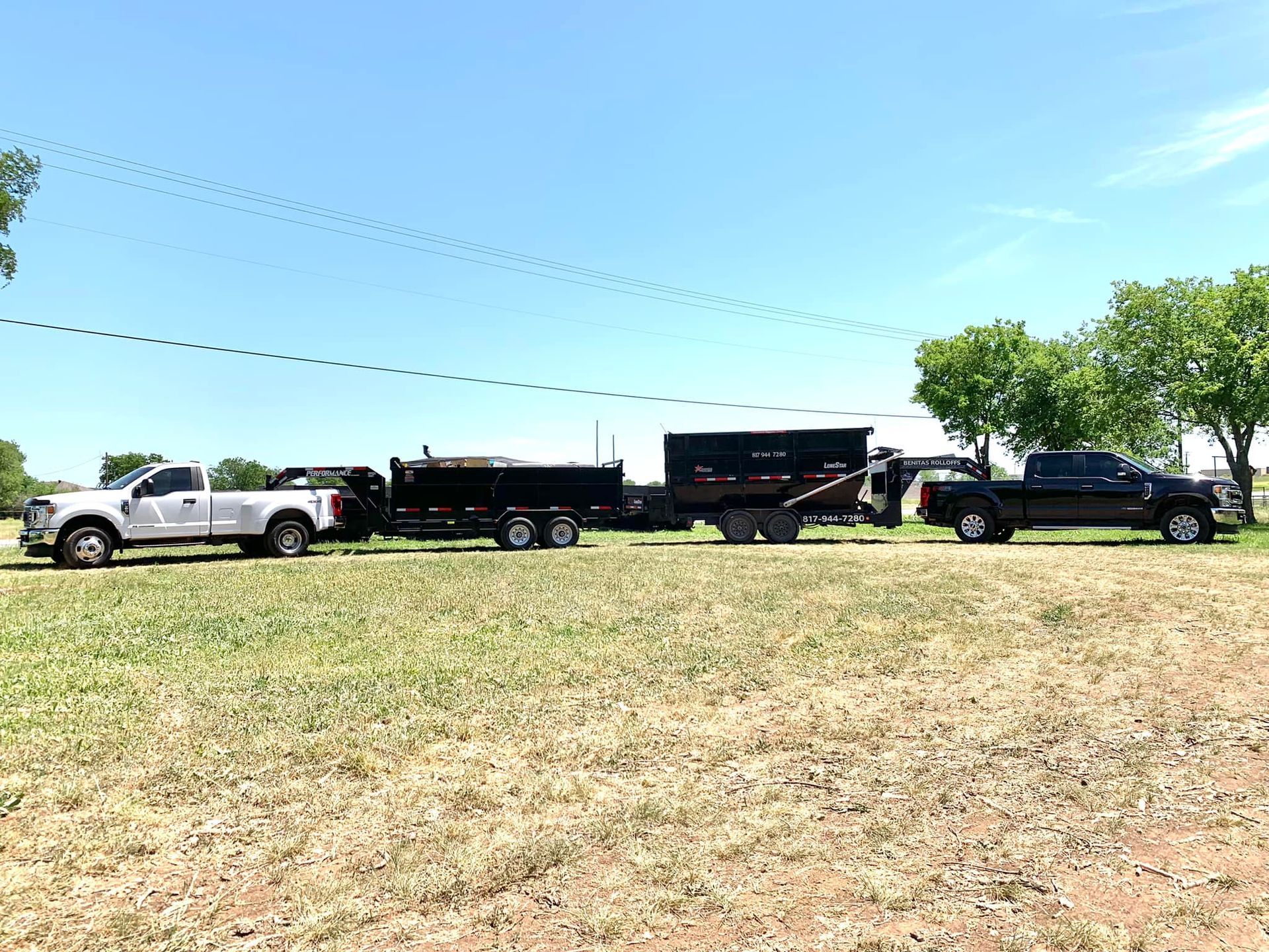 Two trucks are parked next to each other in a grassy field.