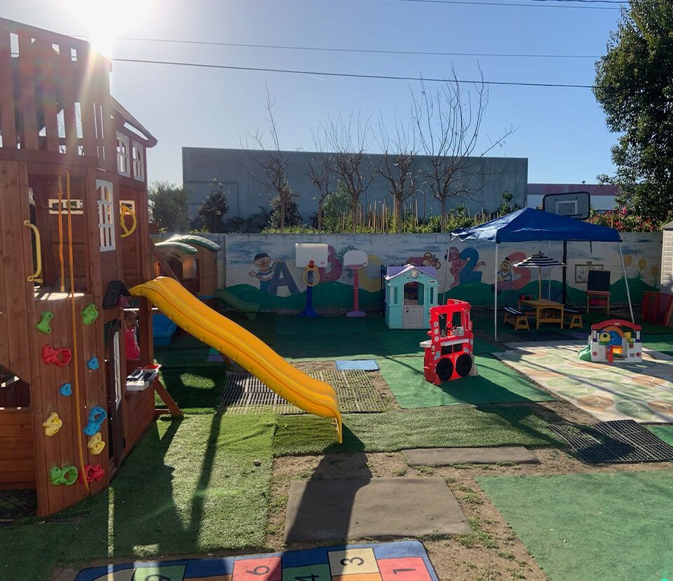 Playground with a wooden structure, slide, and various play structures.