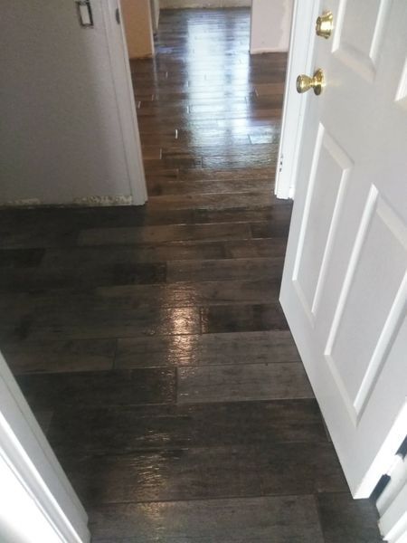 Dark, glossy wood floor in hallway between white doors.