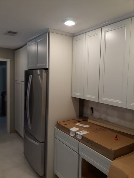 Kitchen with white cabinets, stainless steel fridge, and countertop.