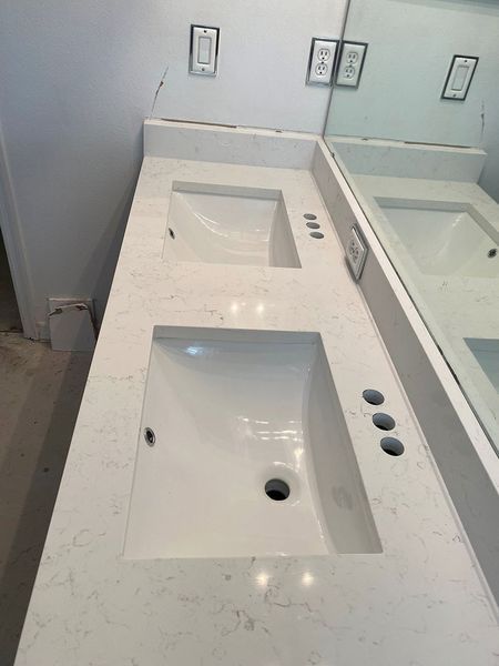 Double bathroom vanity with white sinks, quartz countertop, and mirror.