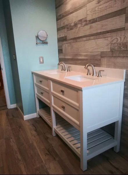 White double-sink vanity with light countertop in a bathroom. Wood-look wall and floor, mint wall.