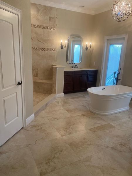 Spacious beige bathroom with walk-in shower, dark wood vanity, and a freestanding tub.