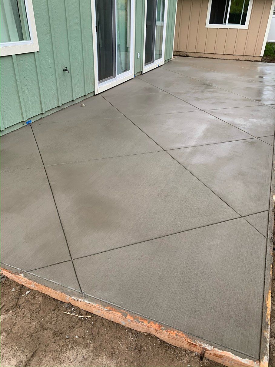 A concrete patio is being built in front of a house.