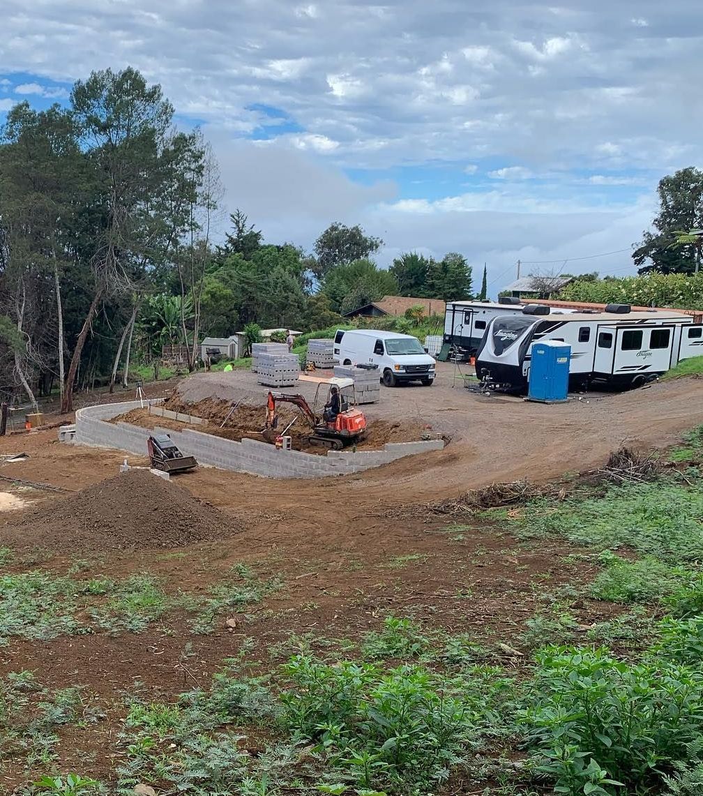 A group of rvs are parked in a dirt lot.