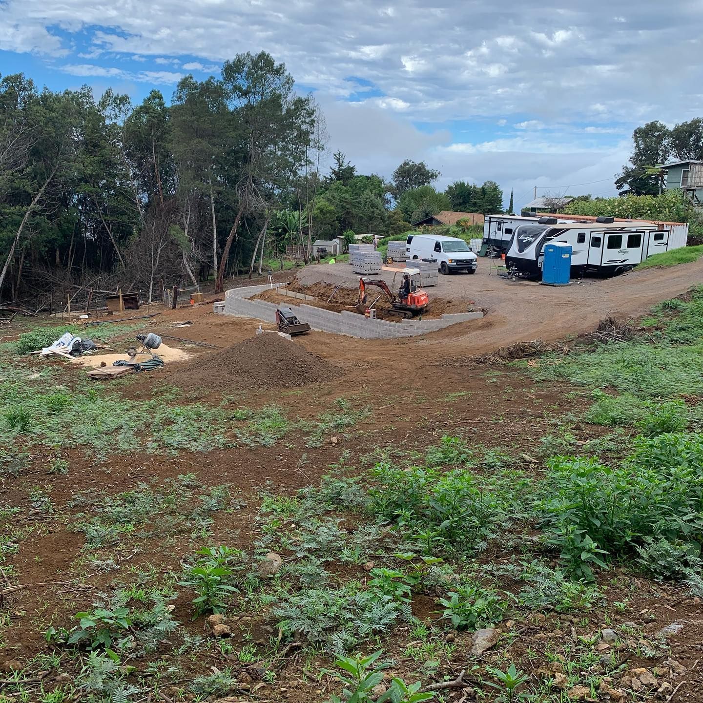 A construction site with a lot of dirt and trees in the background