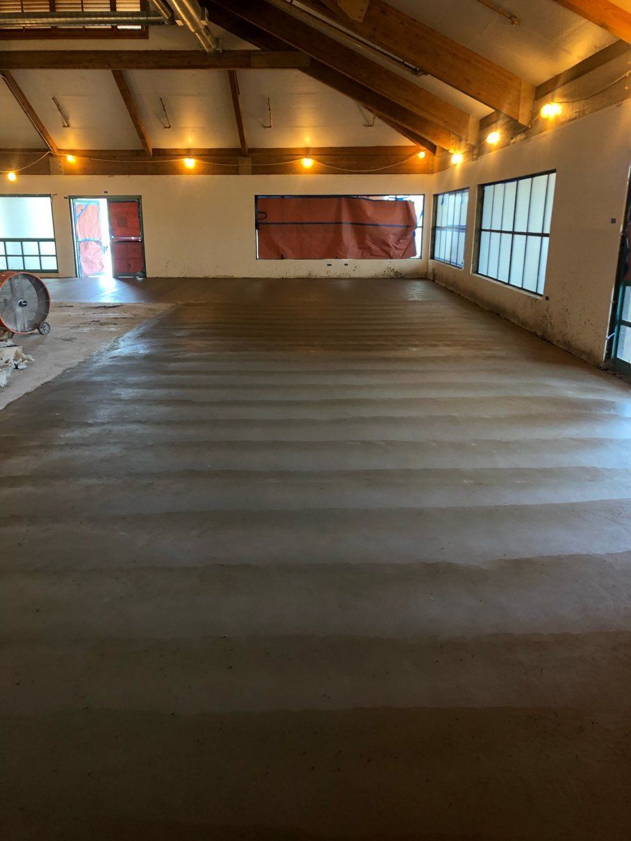 A large room with a concrete floor and a lot of windows.